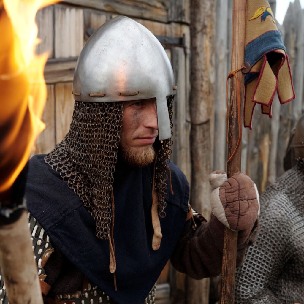 Soldier Wearing Medieval Armor Holding Torches in Fort
